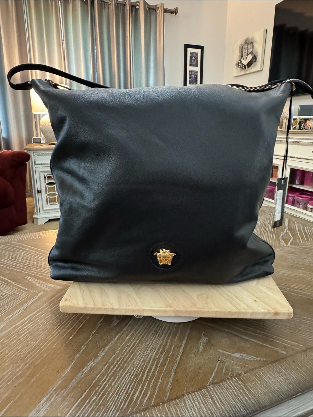 Versace black hobo bag pebbled leather with a gold-tone Medusa head motif.